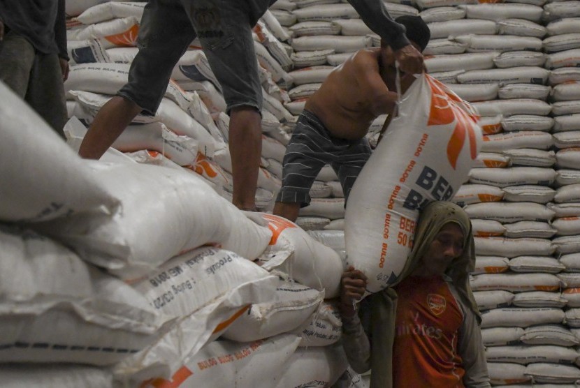 Pekerja memanggul karung beras Bulog untuk dipindahkan kedalam mobil box di Gudang Bulog Kelapa Gading, Jakarta, Jumat (18/10/2019). Stok beras yang tersimpan di gudang-gudang BULOG seluruh Indonesia mencapai 1,7 juta ton