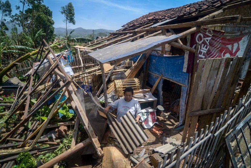 Personel polisi Jabar patungan bantu korban bencana alam. Foto warga merapikan seng atap rumahnya yang terlepas akibat bencana angin ribut yang terjadi di Pangalengan, Kabupaten Bandung, Jawa Barat. 