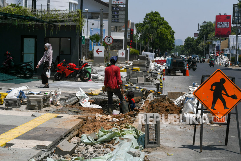 Pekerja Dinas Bina Marga Provinsi DKI Jakarta merevitalisasi trotoar di kawasan Kemang, Jakarta, Selasa (22/10/2019).