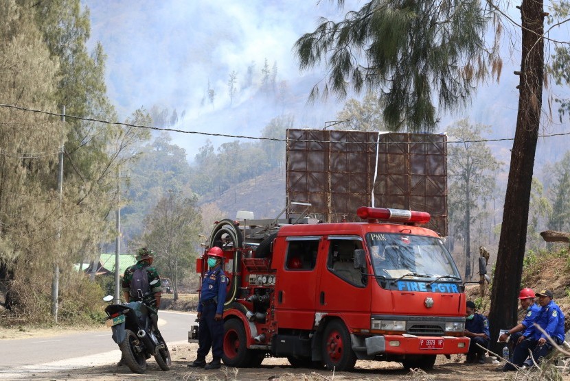 Petugas pemadam kebakaran dengan latar belakang Gunung Ranti, bersiaga di Paltuding, Gunung Ijen, Banyuwangi, Jawa Timur, Selasa (22/10/2019).