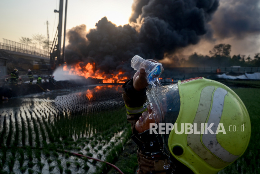 Seorang pemadam kebakaran membasuh mukanya saat berusaha memadamkan kebakaran pipa minyak milik PT Pertamina di Melong, Cimahi, Jawa Barat, Selasa (22/10/2019).