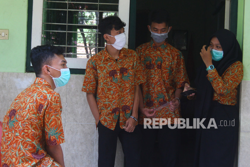 Siswa beraktivitas diluar kelas dengan mengenakan masker agar tidak terjangkit difteri di SMAN 7, Malang, Jawa Timur, Rabu (23/10/2019).