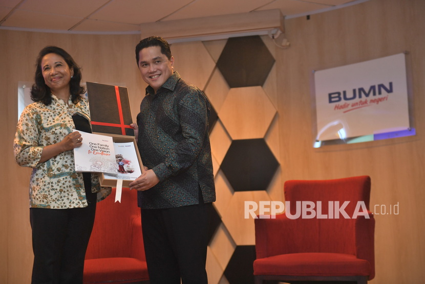 Menteri BUMN Erick Thohir (kanan) menerima buku laporan lima tahunan Kementerian BUMN dari mantan Menteri BUMN Rini Soemarno, saat serah terima jabatan di Kementerian BUMN, Jakarta, Rabu (23/10/2019).