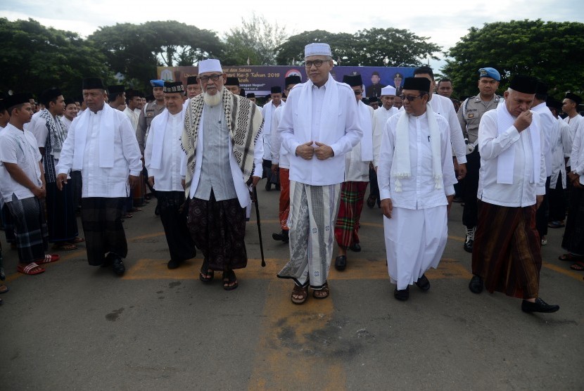 Plt Gubernur Aceh Nova Iriansyah (tengah) bersama rombongan ulama dan Forum Koordinasi Pimpinan Daerah (Forkopimda) memasuki lapangan saat menghadiri apel bersama peringatan Hari Santri Nasional di Banda Aceh, Aceh, Kamis (24/10/2019).