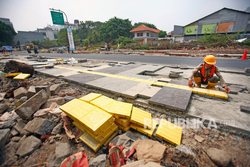 Pekerja melakukan pengerjaan proyek trotoar di kawasan Kemang, Jakarta Selatan, Jumat (25/10/2019). 