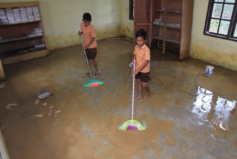 Siswa membersihkan kelas akibat banjir menggenangi Sekolah Dasar Negeri (SDN) Desa Alue Meuganda, Kecamatan Woyla Timur, Aceh Barat, Aceh, Jumat (25/10/2019). 