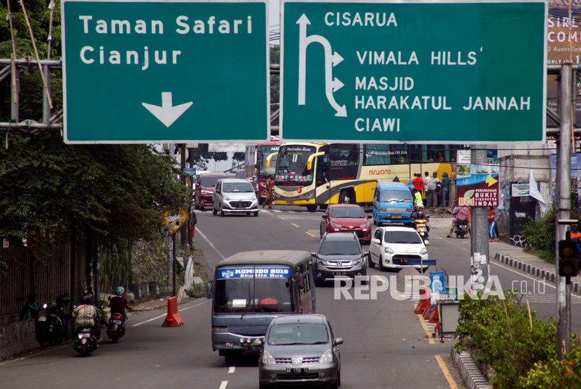 Kendaraan melaju seusai polisi mengembalikan sistem satu arah jalur puncak saat uji coba sistem kanalisasi 2:1 di Jalur Puncak, Bogor, Jawa Barat, Ahad (27/10/2019). 