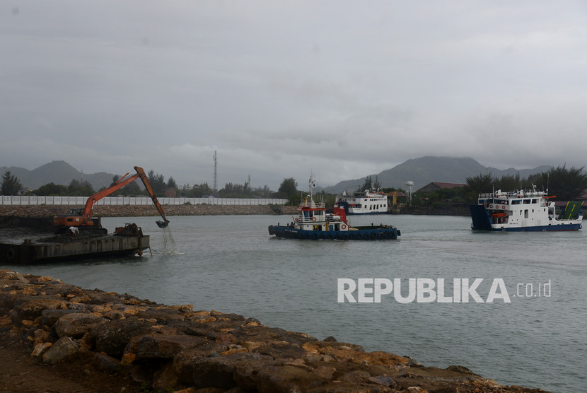 Kapal angkutan pulau KMP Pupuyu dan KMP BRR memasuki pelabuhan saat pekerja mengoperasikan ekskavator mengeruk kolam pelabuhan penyeberangan Ulee Lheue, Banda Aceh, Aceh, Ahad (2710/2019). 