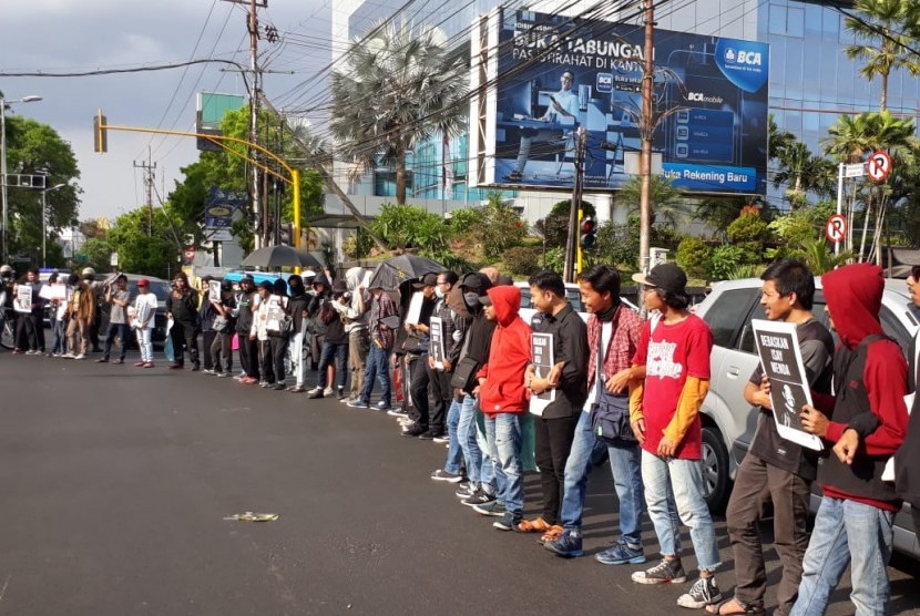Para pemuda yang tergabung dalam Solidaritas Malang Bergerak melakukan aksi demonstrasi di perempatan Kayutangan, Kota Malang, Senin (28/10).