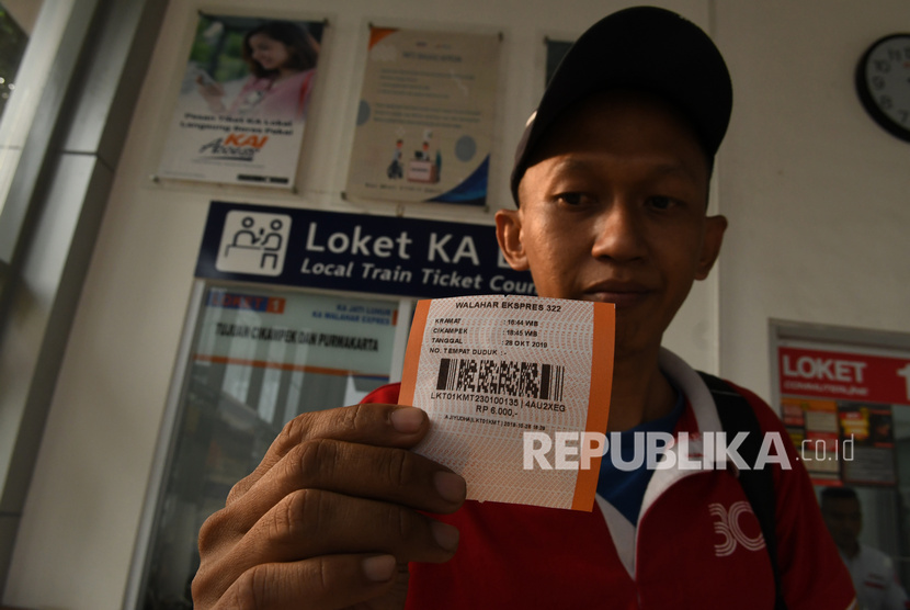 Calon penumpang menunjukan tiket KA lokal Walahar Ekspres di Stasiun Kramat, Jakarta, Senin (28/10).