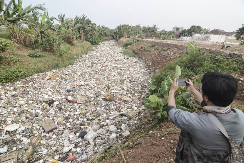 Jurnalis mengambil gambar aliran Kali Jambe di Perumahan Satria Jaya Permai yang dipenuhi sampah, Kabupaten Bekasi, Jawa Barat, Selasa (29/10/19).