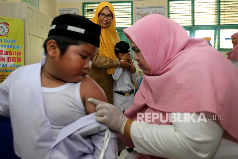 Petugas pusat kesehatan masyarakat (Puskesmas) Ulee Kareng (kanan) memberikan imunisasi vaksin difteri, campak rubella dan vaksin tetanus pada pelajar di Madrasah Ibtidaiyah Negeri (MIN) V, Banda Aceh, Aceh, Selasa (29/10/2019). 