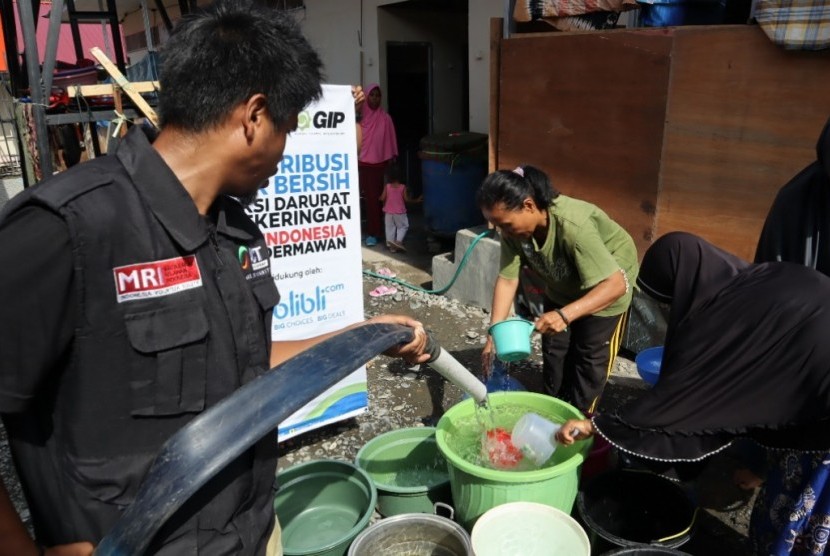 Relawan ACT Sulteng mengisi air bersih di ember-ember yang yang disediakan oleh pengungsi di kompleks Hunian sementara Di Kelurahan Mamboro Induk, Kota Palu