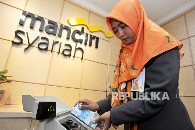 Pegawai Bank Syariah Mandiri (Mandiri Syariah) menghitung uang di Kantor Cabang Jakarta.