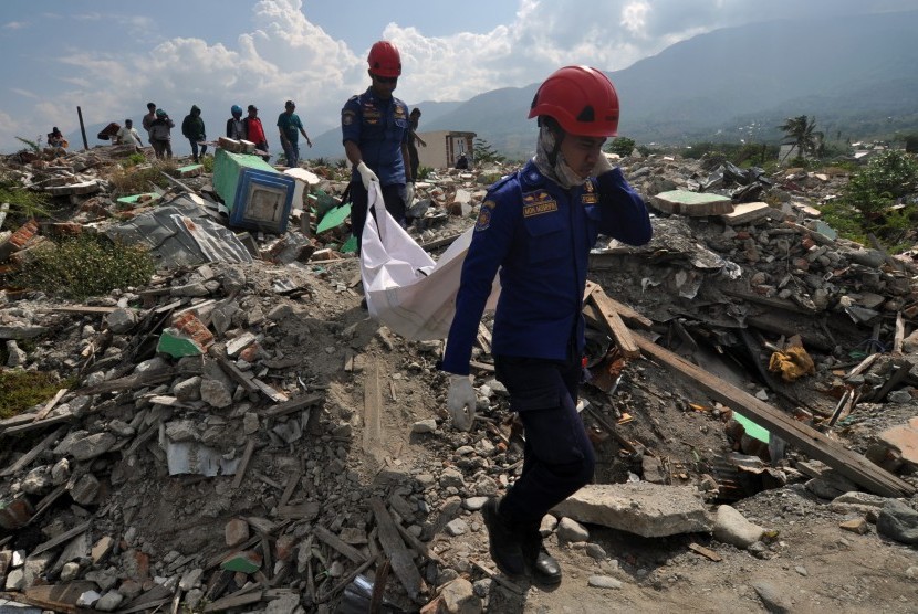 Petugas membawa kantong berisi jenazah korban bencana gempa dan likuefaksi yang ditemukan direruntuhan bangunan di Kelurahan Balaroa, Palu, Sulawesi Tengah, Rabu (30/10/2019). 