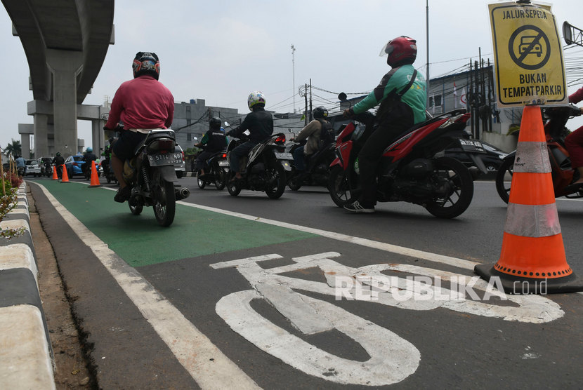 Pengendara sepeda motor melintasi jalur sepeda di Jalan Fatmawati, Jakarta, Kamis (31/10/2019).