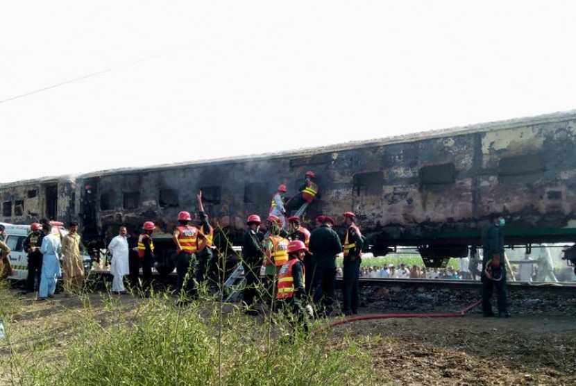 Para petugas menyelamatkan para korban kereta yang terbakar di dekat Rahim Yar Khan, Pakistan, Kamis (31/10).  EPA-EFE/STRINGER