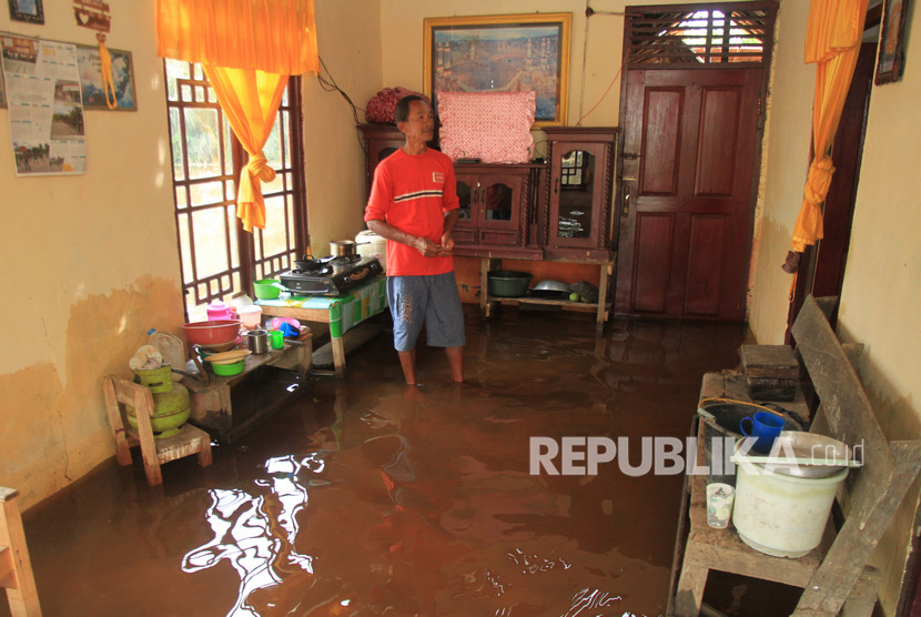 Seorang warga berada di dalam rumahnya yang terendam banjir Di Desa Cot Amun, Samatiga, Aceh Barat, Aceh, Jumat (1/11/2019). 