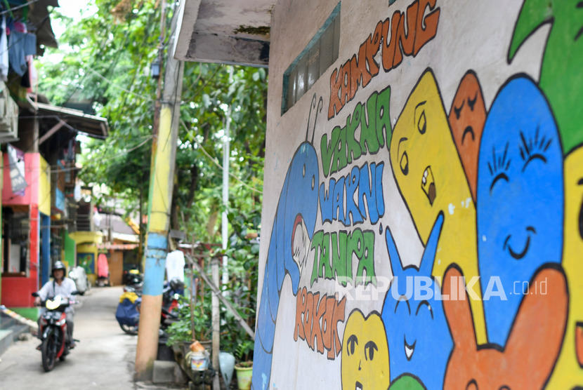 Warga melintas didekat mural kampung warna-warni tanpa rokok di Jakarta, Rabu (6/11/2019). 