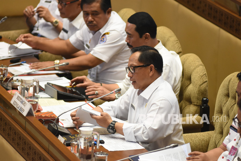 Menteri Dalam Negeri Tito Karnavian (kanan) menyampaikan paparannya saat mengikuti rapat kerja dengan Komisi II DPR di Kompleks Parlemen, Senayan, Jakarta, Rabu (6/11/2019). 