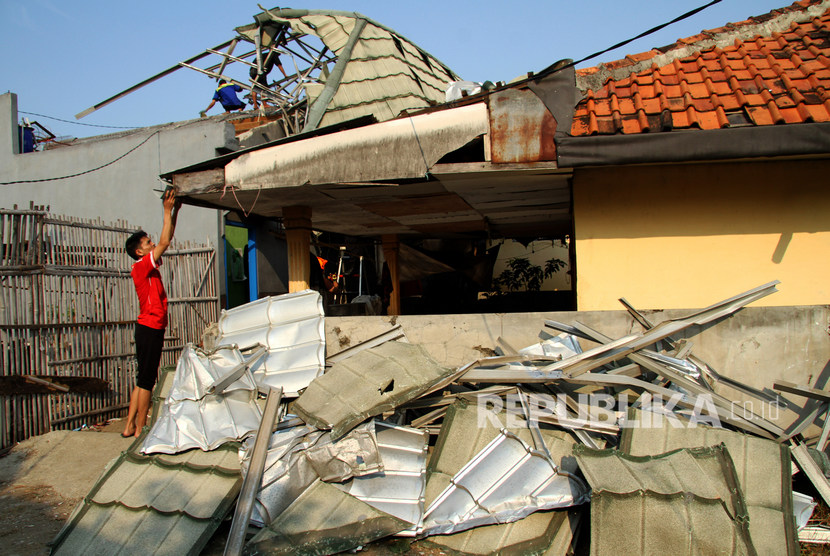 Warga memperbaiki rumah yang rusak akibat diterjang hujan disertai angin kencang 