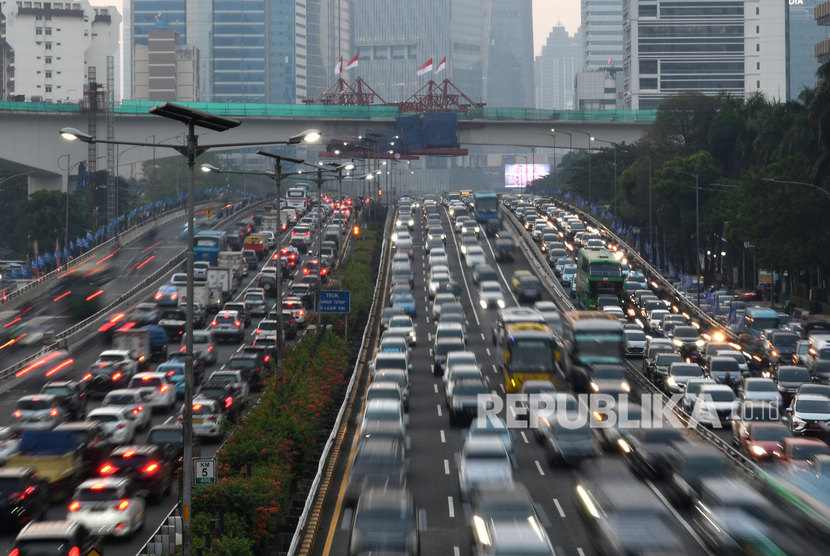 Sejumlah kendaraan bermotor melintas dengan latar belakang pembangunan LRT Jakarta. Mulai 1 Desember 2019 pengguna LRT dikenakan tarif Rp 5.000.
