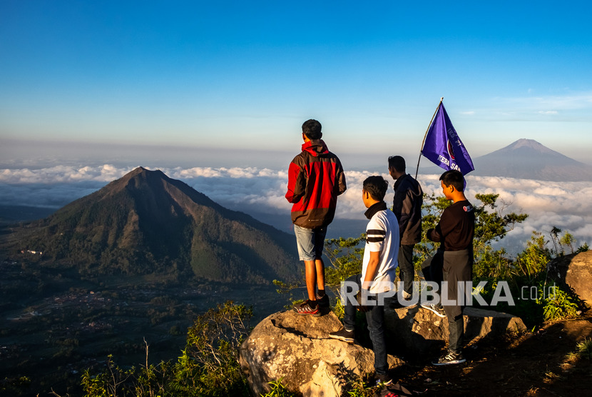 Sejumlah wisatawan menikmati suasana matahari terbit di Gunung Telomoyo, Desa Sepakung, Banyubiru, Kabupaten Semarang, Jawa Tengah, Ahad (10/11/2019).