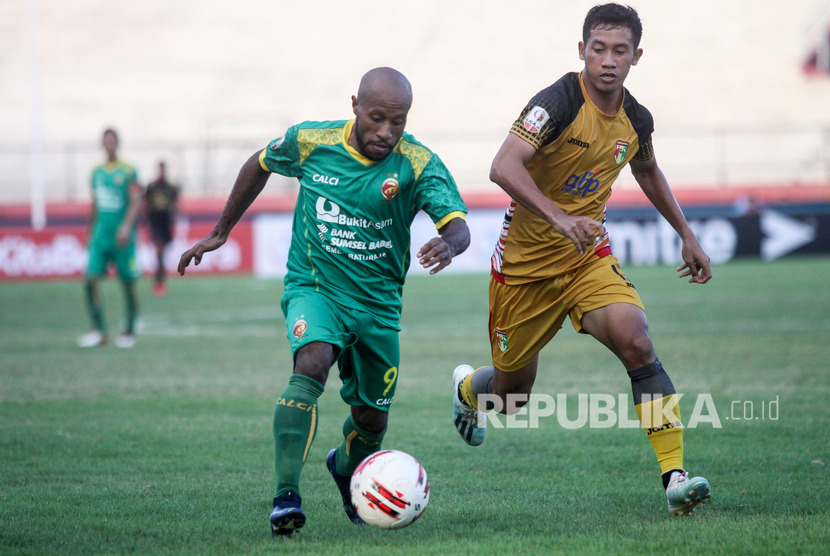 Pesepak bola Sriwijaya FC Yohanis Nabar (kiri) mendapat hadangan pesepak bola Mitra Kukar A agustiar (kanan) pada Delapan Besar Liga 2 2019 di Stadion Gelora Delta Sidoarjo, Jawa Timur, Rabu (13/11/2019).