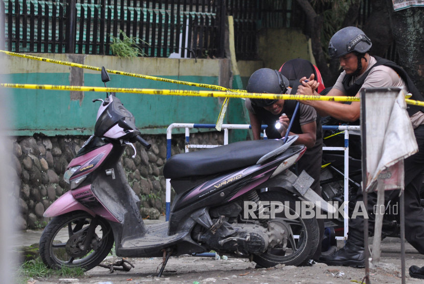 Personel penjinak bom dari Gegana Brimob Polda Sumatera Utara memeriksa sebuah sepeda motor yang diduga milik pelaku bom bunuh diri yang terparkir di depan Mapolrestabes Medan, Sumatera Utara, Rabu (13/11/2019).