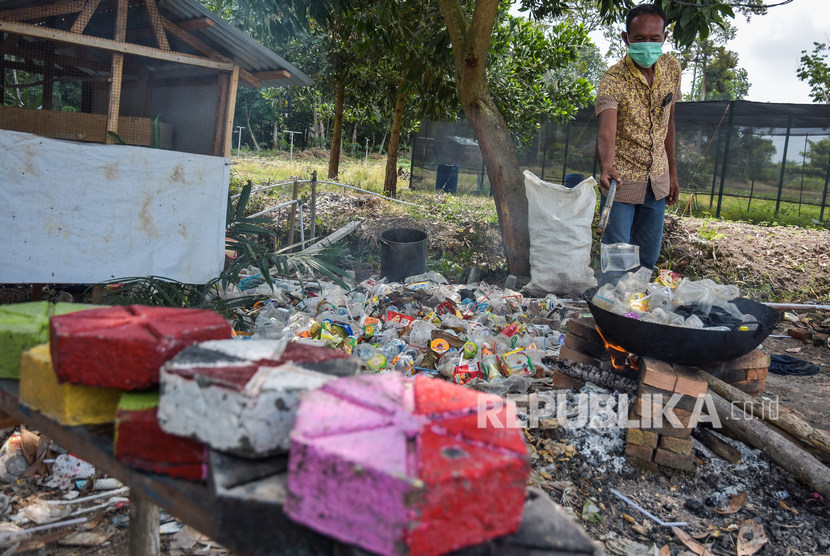 Sejumlah pengelola objek wisata Taman Bunga Impian Okura melumerkan sampah plastik untuk dijadikan paving blok di Kota Pekanbaru, Riau, Senin (19/11/2019)