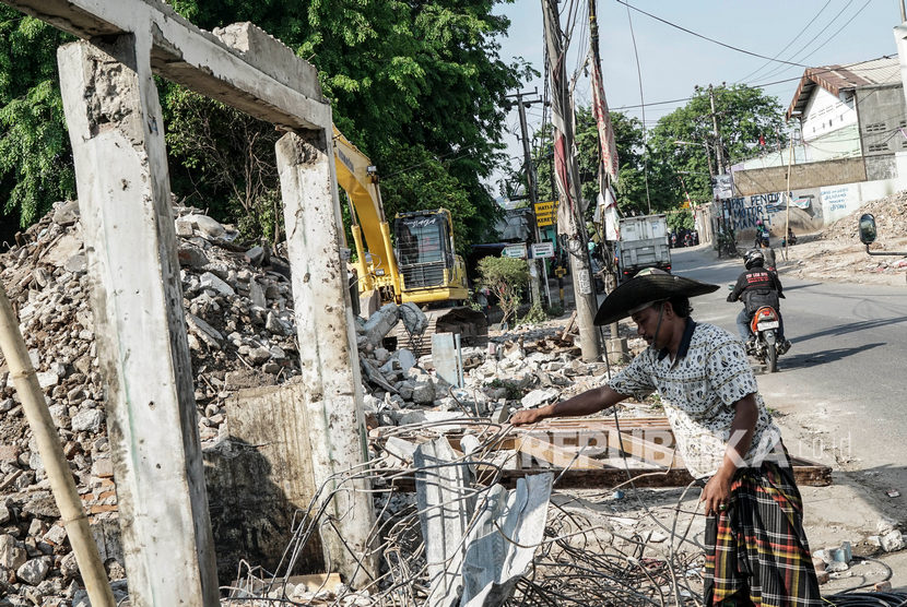 Sejumlah pengepul mencari besi sisa pembongkaran rumah untuk proyek jalan bawah tanah (Underpass) di Cibitung, Kabupaten Bekasi, Jawa Barat.
