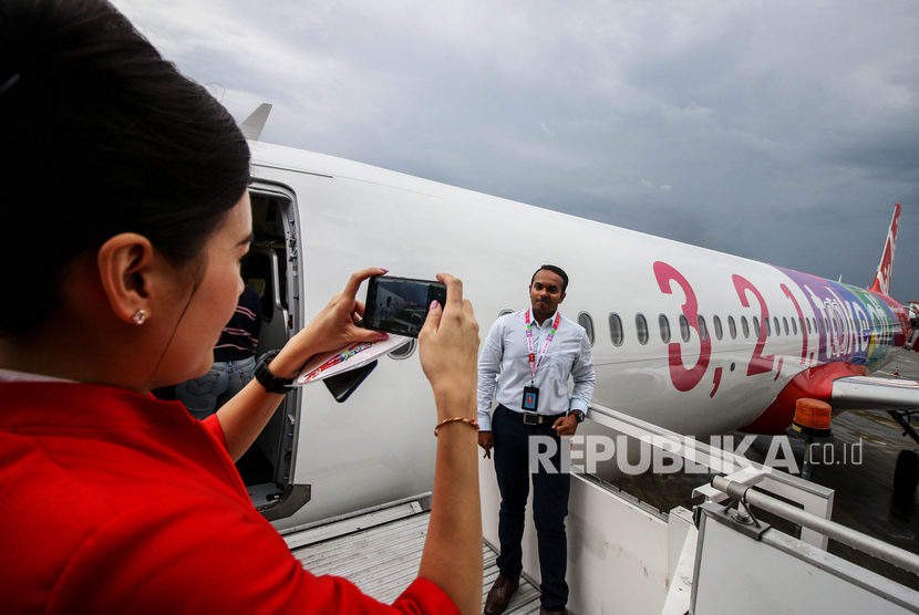 Karyawan berfoto di depan pesawat Airbus A321NEO milik maskapai AirAsia saat tiba di Paint Hangar, Sepang Aircraft Engineering (SAE), Kuala Lumpur International Airport, Malaysia, Jumat (22/11/2019). 