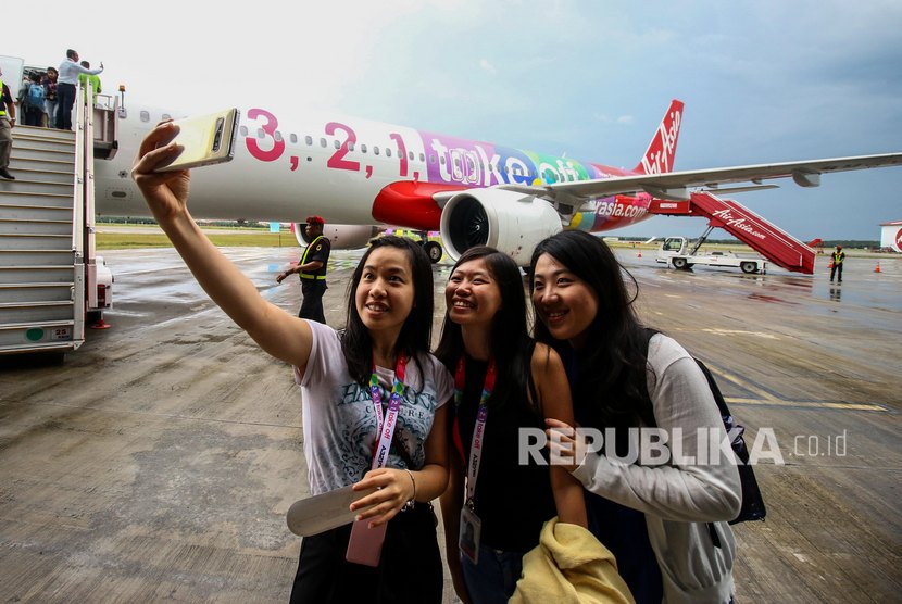 Wartawan berswafoto di depan Pesawat Airbus A321NEO milik maskapai AirAsia saat tiba di Paint Hangar, Sepang Aircraft Engineering (SAE), Kuala Lumpur International Airport, Malaysia, Jumat (22/11/2019). 