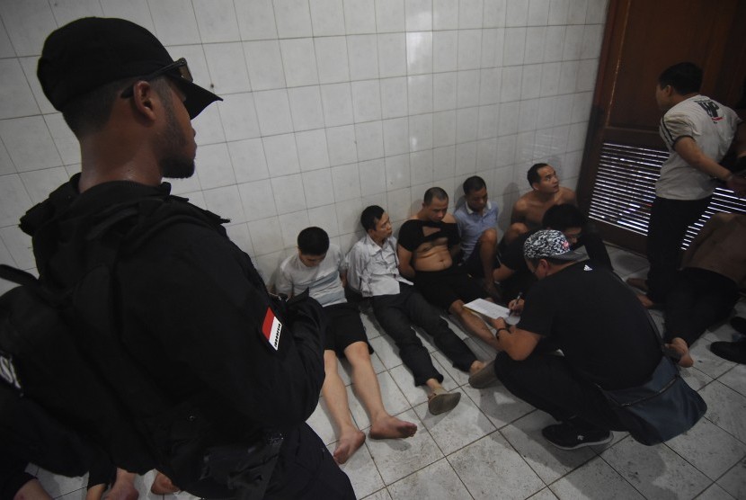 Polisi menginterogasi WNA Cina saat dilakukan penggerebekan terhadap sindikat pelaku penipuan di Perumahan Mega Kebon Jeruk, Jakarta, Senin (25/11/2019).