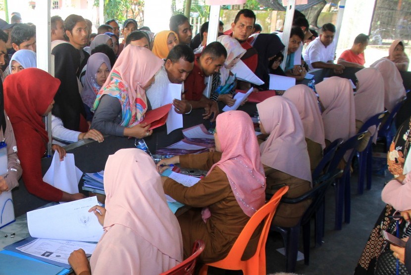 Puluhan pelamar Calon Pegawai Negeri Sipil (CPNS) antre untuk menyerahkan berkas pendaftaran lamaran di halaman komplek Dinas Pendidikan Kabupaten Aceh Barat, di Aceh, Senin (25/11/2019). 