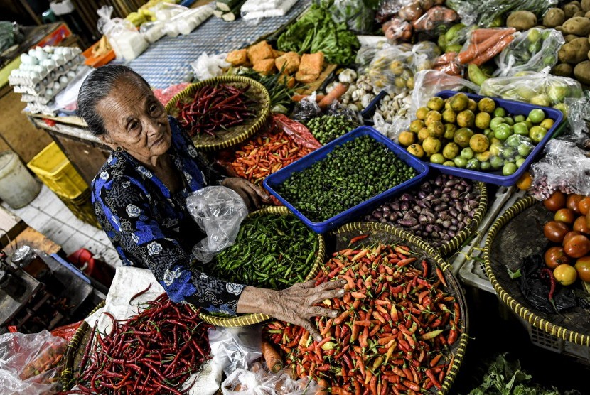 Pedagang sayur menata dagangannya di Pasar 