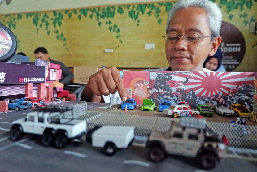 Penggemar mobil miniatur (diecast) menyusun mobil bersama diorama saat mengikuti kompetisi 