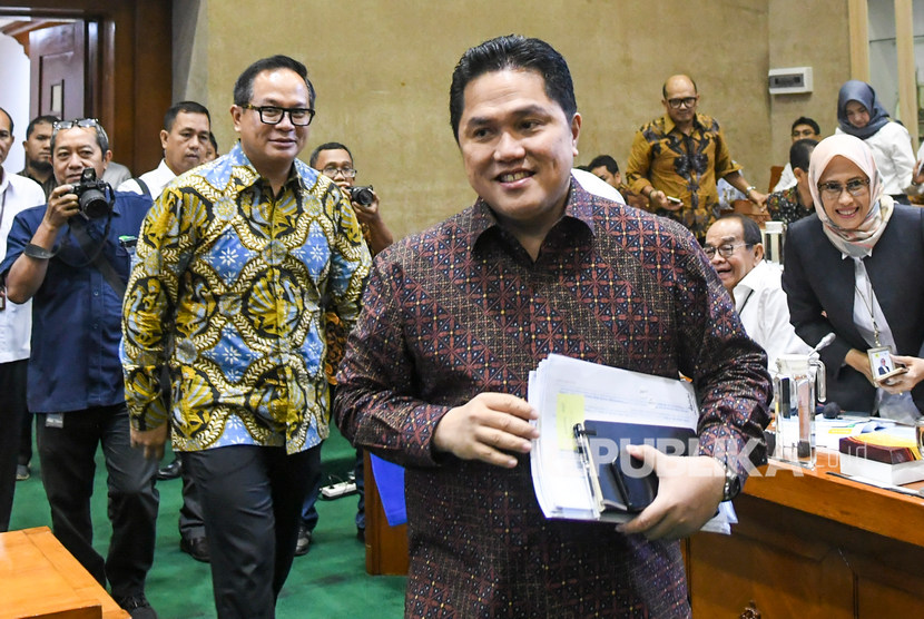 Menteri Badan Usaha Milik Negara (BUMN) Erick Thohir (kanan) bersama Wakil Menteri BUMN Kartika Wirjoatmodjo (kedua kiri) tiba di ruang komisi untuk mengikuti rapat dengan Komisi VI DPR, di kompleks Parlemen, Jakarta, Senin (2/12/2019). 