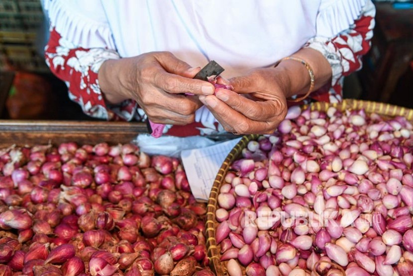 Pedagang mengupas bawang merah. Jelang hari Natal dan Tahun Baru 2020, sebagian harga bahan pokok di Pasar Kosambi, Kota Bandung merangsek naik. 