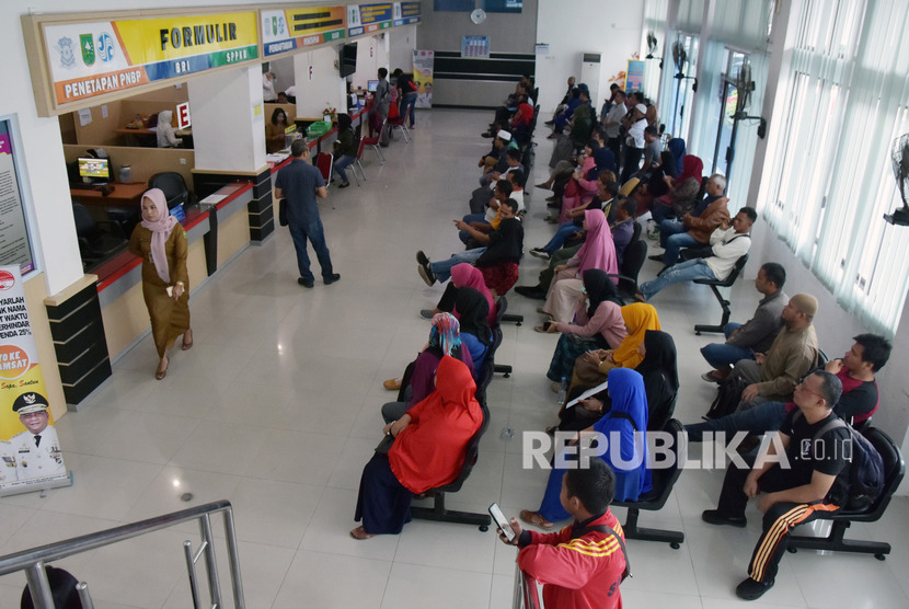 Samsat Riau Kurangi Jam Operasional. Sejumlah warga mengantre membayar pajak kendaraan bermotor di Kantor Samsat Kota Pekanbaru, Riau. 
