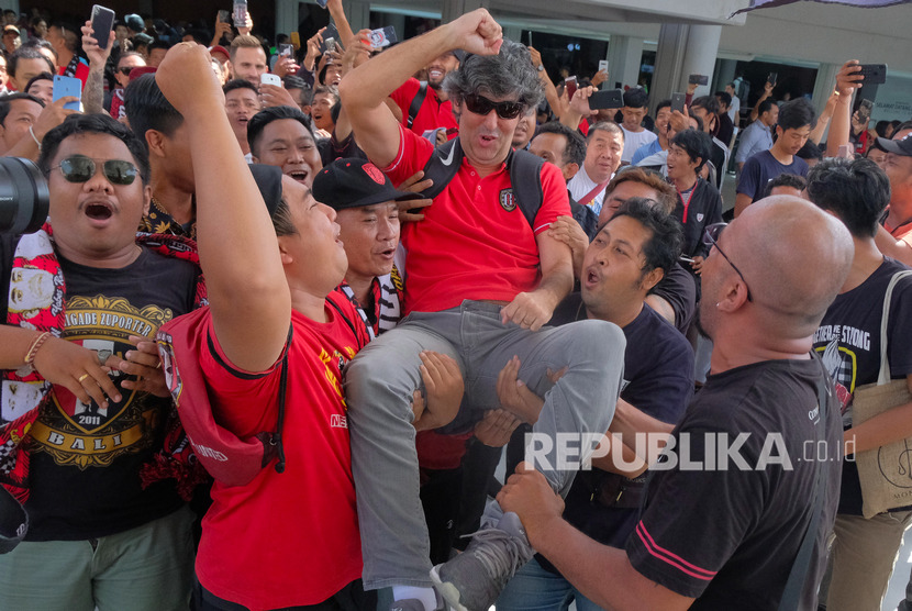 Pelatih Bali United Stefano Cugurra Teco (tengah) disambut para suporter saat tiba di Bandara I Gusti Ngurah Rai, Badung, Bali, Selasa (3/12/2019).