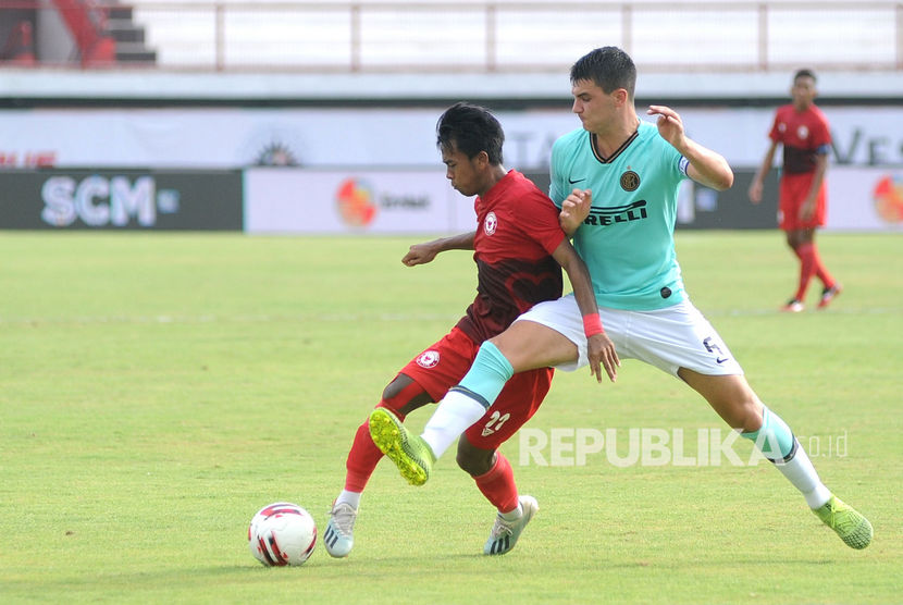 Pesepak bola Indonesia U-20 All Stars Mochammad Supriadi (kiri) berebut bola dengan pesepak bola Inter Milan U-18 Eduardo Sottini (kanan) saat pertandingan U-20 International Cup 2019 di Stadion Kapten I Wayan Dipta, Gianyar, Bali, Kamis (5/12/2019).