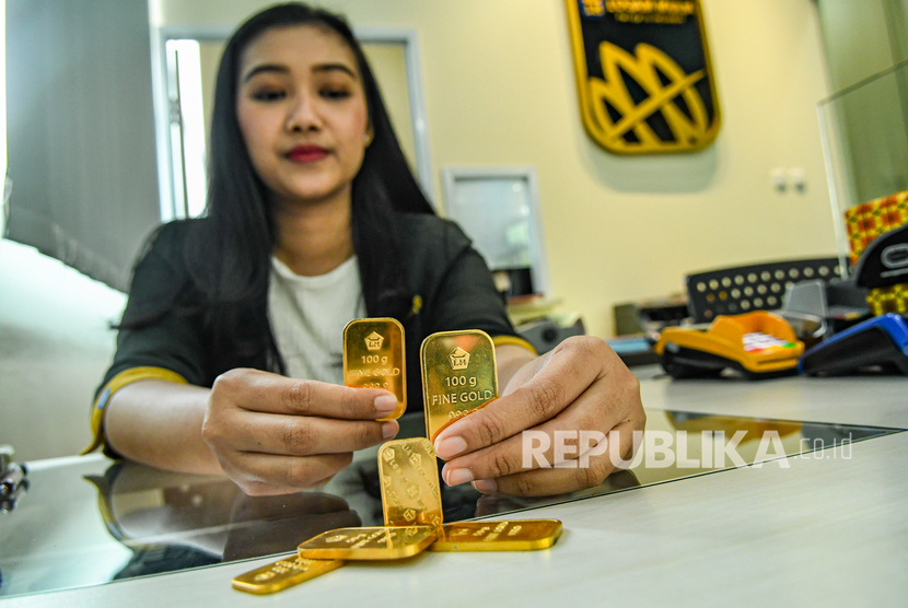 Petugas menunjukkan sampel emas batangan di Butik Emas Logam Mulia, Jakarta, Senin (9/12/2019). 