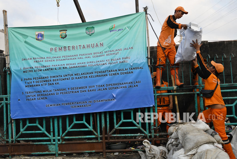 Sejumlah petugas membersihkan sampah sisa bekas pedagang kaki lima (PKL) di trotoar Jalan Stasiun Senen, Pasar Senen, Jakarta, Senin (9/12/2019). 