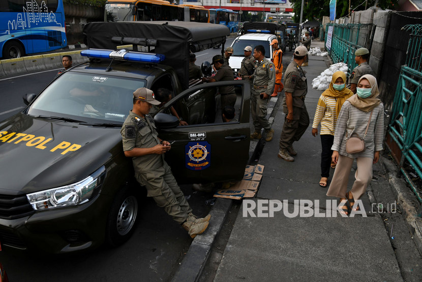 Sejumlah petugas Satpol PP berjaga di trotoar Jalan Stasiun Senen, Pasar Senen, Jakarta, Senin (9/12/2019). 