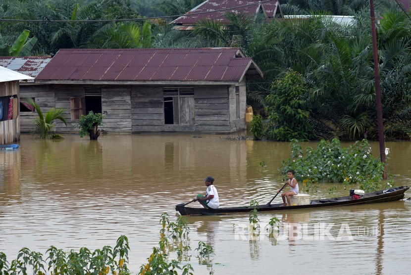 Sejumlah warga terpaksa menggunakan sampan melintasi banjir akibat luapan Sungai Subayang di Kecamatan Gunung Sahilan Kabupaten Kampar, Riau, Rabu (11/12/2019). Banjir akibat tingginya intensitas hujan di Riau menelan satu korban jiwa.