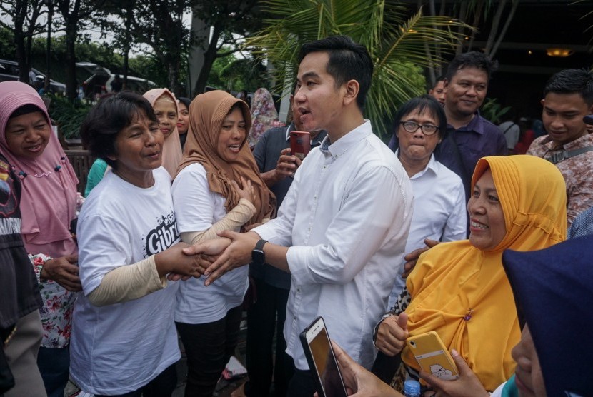 Putra sulung Presiden Joko Widodo, Gibran Rakabuming Raka (ketiga kanan) menyalami warga saat akan berangkat mendaftar bakal calon Wali Kota di Graha Saba Buana, Solo, Jawa Tengah, Kamis (12/12/2019). 