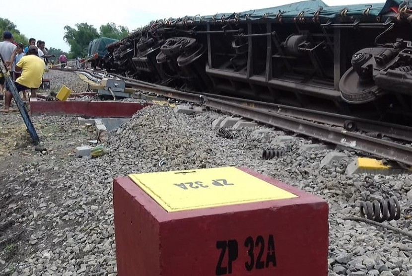Kondisi rangkaian gerbong kereta barang bermuatan semen yang tergelincir di emplasemen Stasiun Doplang, Kabupaten Blora, Jawa Tengah, Kamis (12/12). Penyebab musibah ini masih dalam investigasi PT KAI.