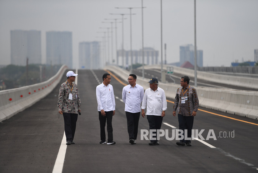 Presiden Joko Widodo (kedua kiri) didampingi Gubernur Jawa Barat Ridwan Kamil (tengah), Menteri PUPR Basuki Hadimuljono (kedua kanan), Dirut KCIC Chandra Dwiputra (kiri) dan Dirjen Perkeretaapian Zulfikri (kanan) berjalan usai meresmikan Jalan Tol Layang Jakarta-Cikampek di Bekasi, Jawa Barat, Kamis (12/12/2019). 