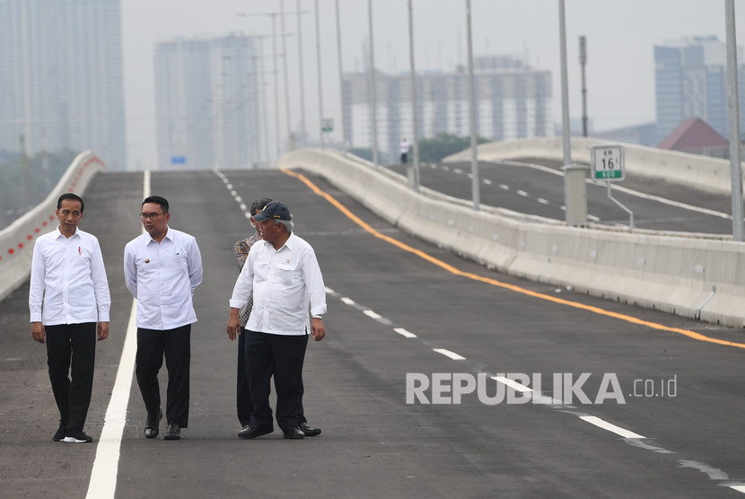 Presiden Joko Widodo (kiri) didampingi Gubernur Jawa Barat Ridwan Kamil (tengah) dan Menteri PUPR Basuki Hadimuljono (kanan) berjalan usai meresmikan Jalan Tol Layang Jakarta-Cikampek di Bekasi, Jawa Barat.